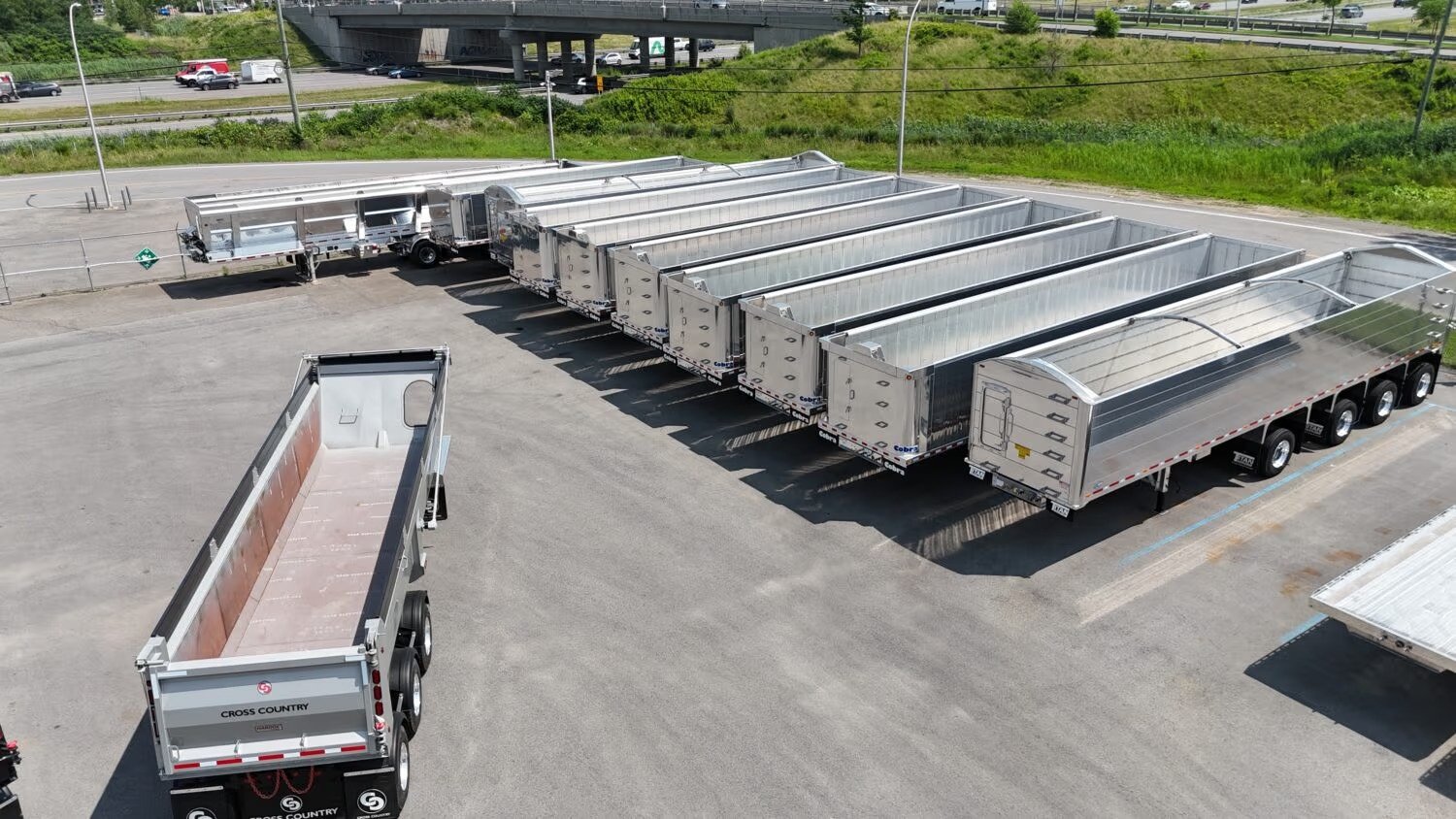 Une remorque de transport lourd de marchandises en aluminium sur une route régionale du Québec.